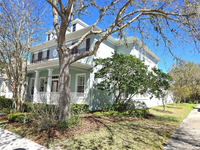 view of property exterior with a garage, covered porch, and stucco siding