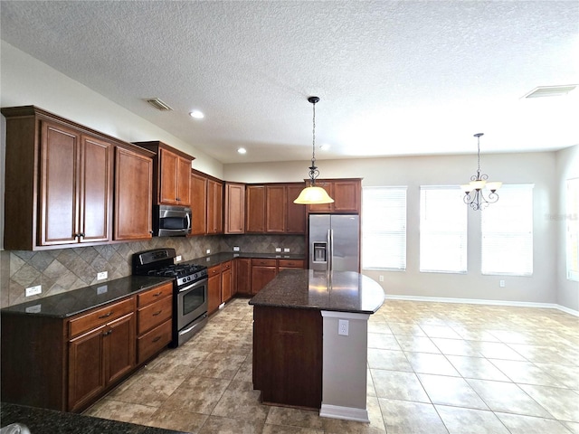 kitchen featuring pendant lighting, appliances with stainless steel finishes, visible vents, and decorative backsplash