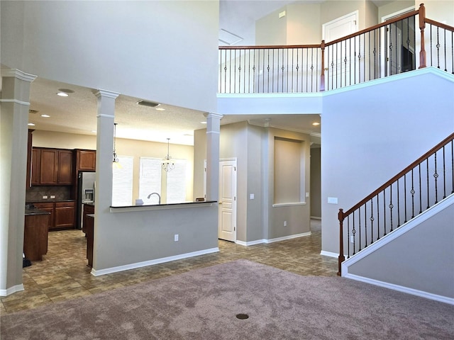 living room with dark colored carpet, ornate columns, and stairs