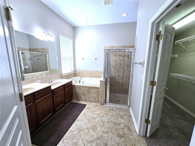 bathroom featuring a walk in closet, a sink, a shower stall, and a bath