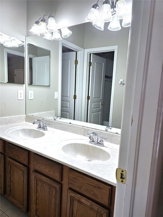 full bath featuring tile patterned flooring, a sink, a spacious closet, and double vanity