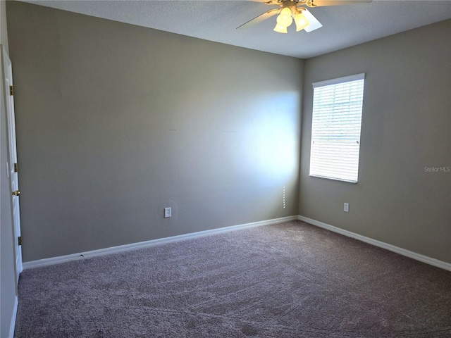 carpeted spare room featuring a ceiling fan and baseboards