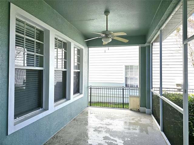 unfurnished sunroom with a ceiling fan