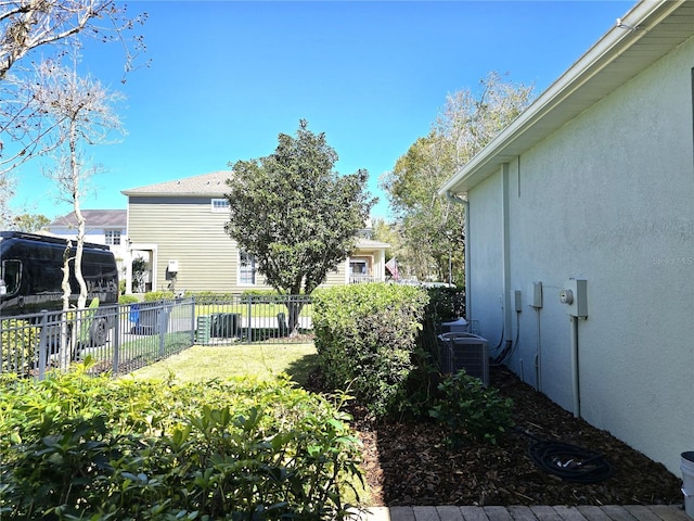 view of yard featuring fence and central AC