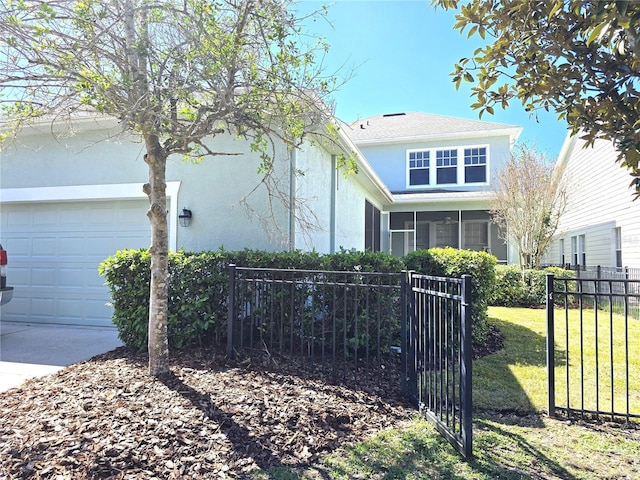 view of front facade with an attached garage, a front yard, fence, and stucco siding