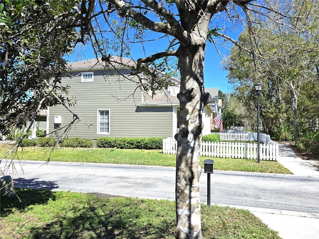 view of home's exterior with a yard and fence