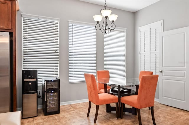 dining space featuring a chandelier, light tile patterned floors, and baseboards