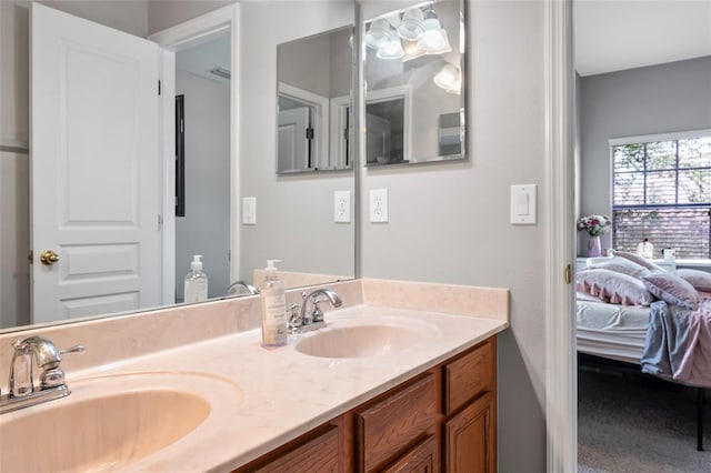 ensuite bathroom with a sink, ensuite bath, and double vanity