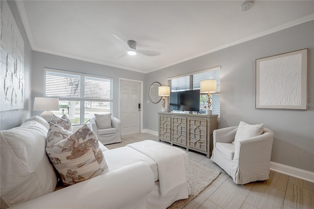 living area featuring baseboards, ornamental molding, and a ceiling fan