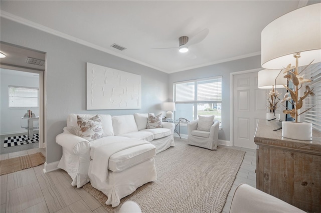 living room featuring a ceiling fan, plenty of natural light, visible vents, and crown molding