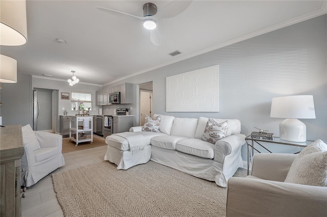 living area with a ceiling fan, visible vents, and crown molding