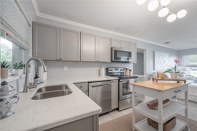 kitchen featuring stainless steel appliances, a sink, visible vents, gray cabinets, and crown molding