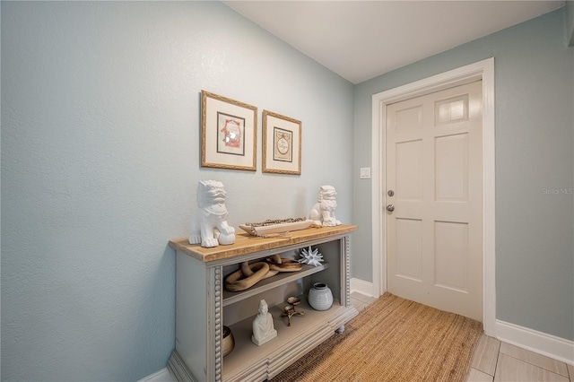 doorway to outside with baseboards