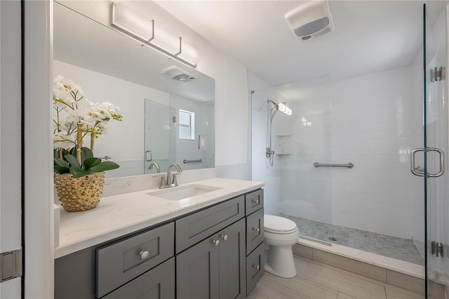 bathroom featuring a stall shower, vanity, and toilet