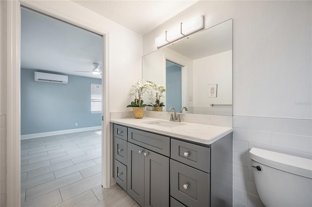 bathroom with ceiling fan, a wall mounted air conditioner, vanity, and toilet