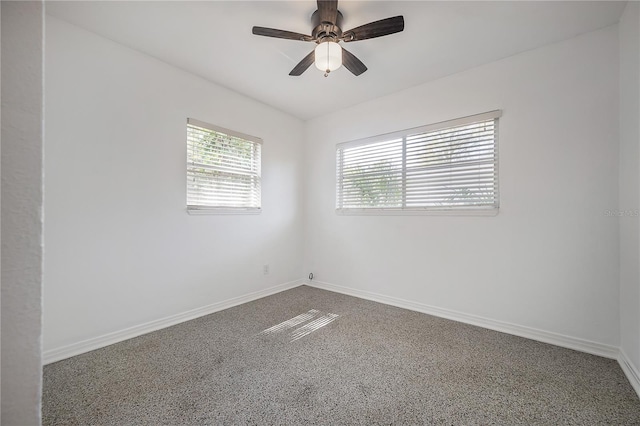 unfurnished room featuring a ceiling fan and baseboards