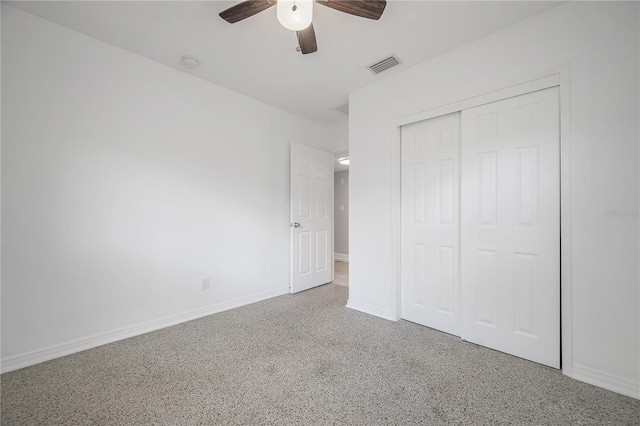 unfurnished bedroom featuring a closet, visible vents, ceiling fan, baseboards, and speckled floor