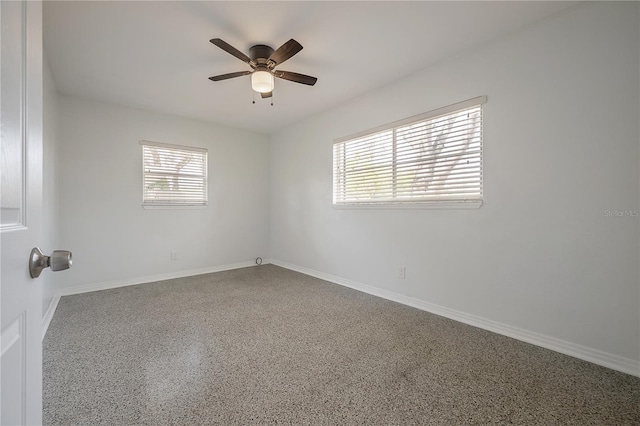 unfurnished room featuring baseboards, a ceiling fan, and speckled floor