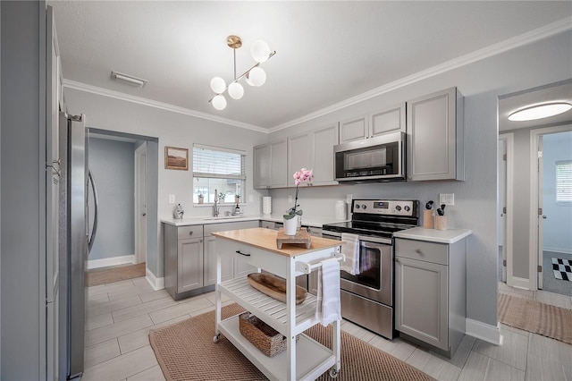 2918 W Ellis Dr, Tampa, FL 33611 - kitchen featuring light countertops, a sink, appliances with stainless steel finishes, and gray cabinets