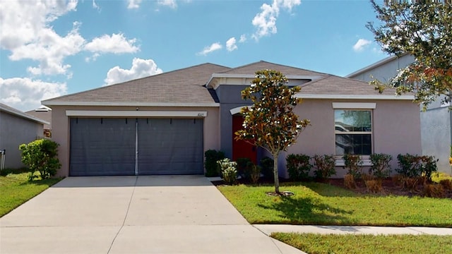 ranch-style home with concrete driveway, a front yard, an attached garage, and stucco siding