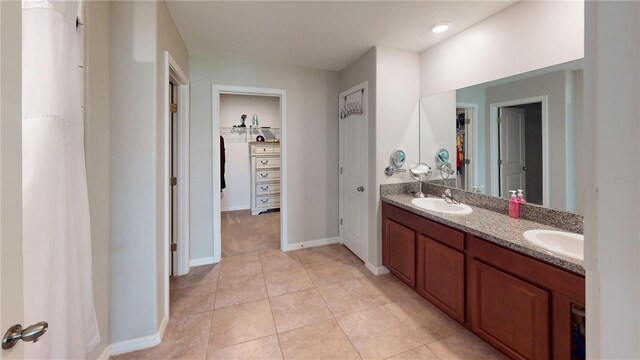 10115 Paradise Fish Dr, Riverview, FL 33578 - bathroom featuring tile patterned flooring, double vanity, baseboards, and a sink