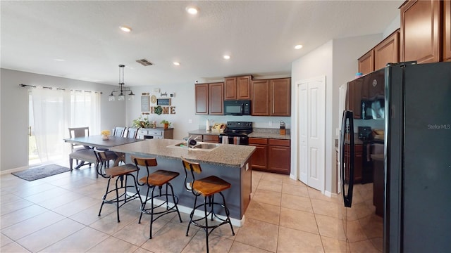 10115 Paradise Fish Dr, Riverview, FL 33578 - kitchen with visible vents, black appliances, a breakfast bar, a sink, and light tile patterned floors