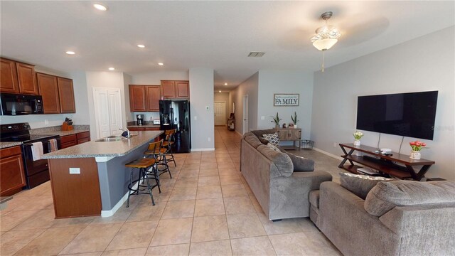 10115 Paradise Fish Dr, Riverview, FL 33578 - kitchen featuring black appliances, a center island with sink, a sink, open floor plan, and a breakfast bar area