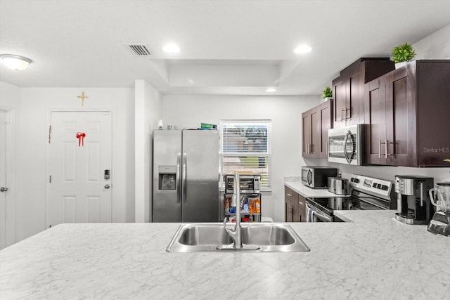 kitchen featuring stainless steel appliances, recessed lighting, light countertops, visible vents, and dark brown cabinetry