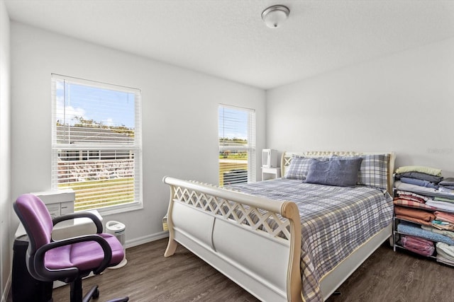 bedroom with baseboards and wood finished floors