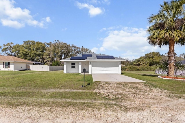 view of front facade featuring concrete driveway, roof mounted solar panels, fence, a garage, and a front lawn