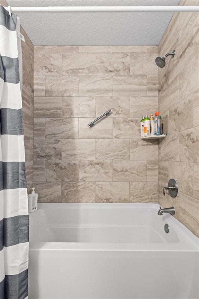 full bathroom with shower / bath combination with curtain and a textured ceiling