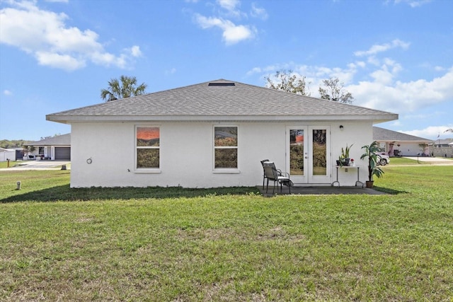 back of house with french doors, roof with shingles, a yard, and stucco siding