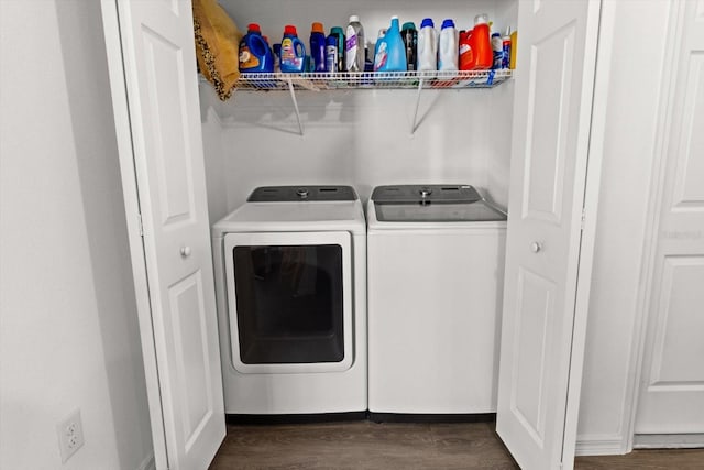 clothes washing area featuring laundry area, dark wood finished floors, and washer and clothes dryer