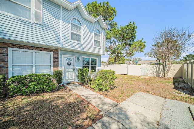 view of front of home featuring a fenced backyard and brick siding