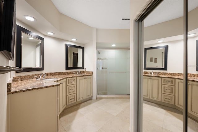 full bathroom featuring a sink, two vanities, and a shower stall