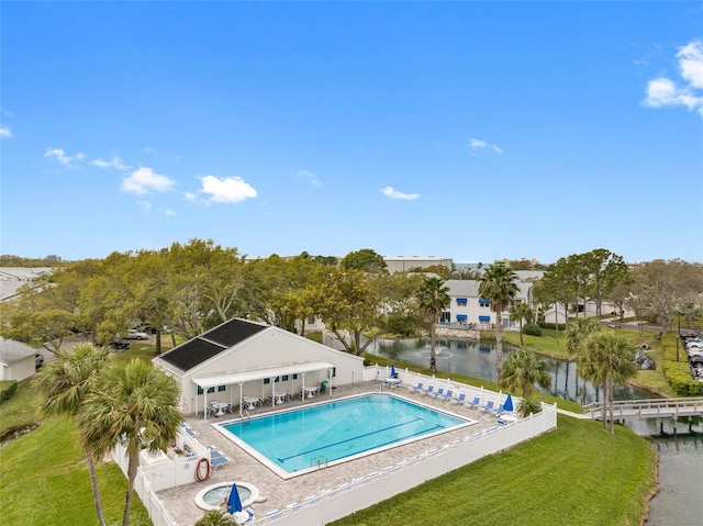 pool featuring a yard, a patio, fence, and a water view