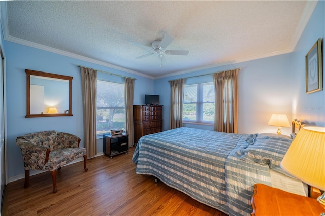 bedroom with ornamental molding, a textured ceiling, a ceiling fan, and wood finished floors