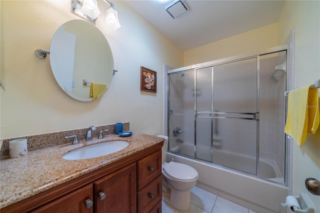 full bath with combined bath / shower with glass door, toilet, vanity, and tile patterned flooring