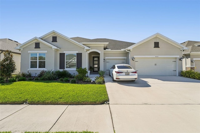 view of front of property featuring stucco siding, a shingled roof, concrete driveway, an attached garage, and a front lawn