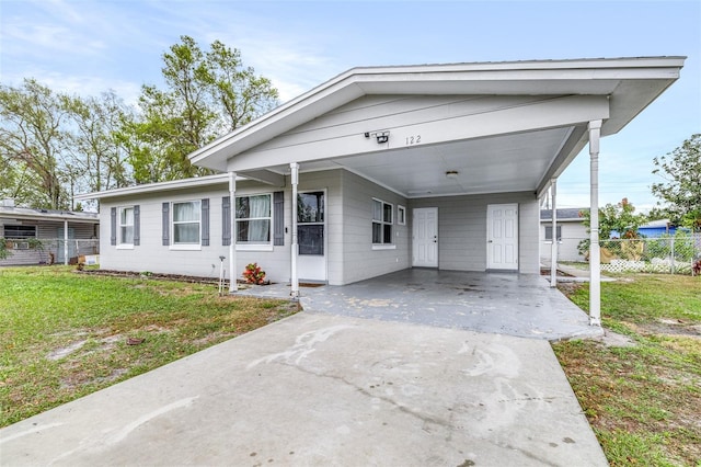 view of front of home with driveway, fence, an attached carport, and a front yard