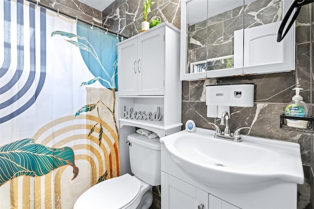 bathroom featuring tasteful backsplash, vanity, toilet, and curtained shower