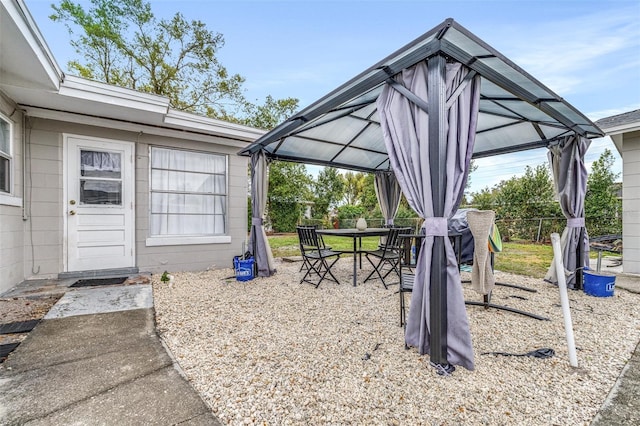 exterior space featuring outdoor dining space, fence, and a gazebo