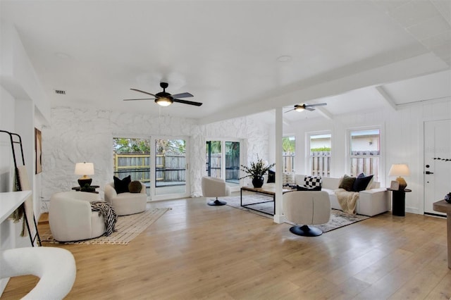 living area featuring visible vents, wood finished floors, and a ceiling fan