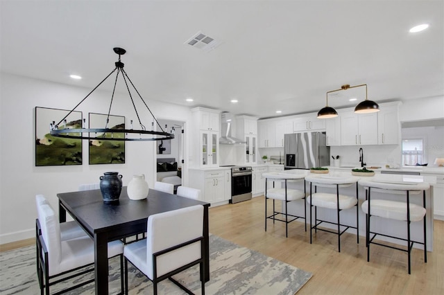 dining space featuring light wood-style floors, baseboards, visible vents, and recessed lighting