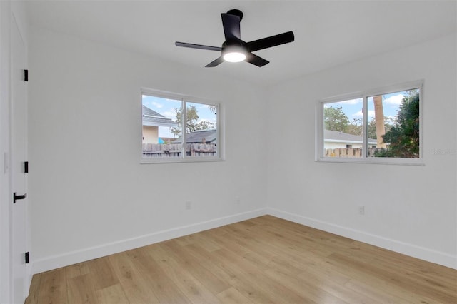 unfurnished room featuring a healthy amount of sunlight, light wood-style flooring, and baseboards