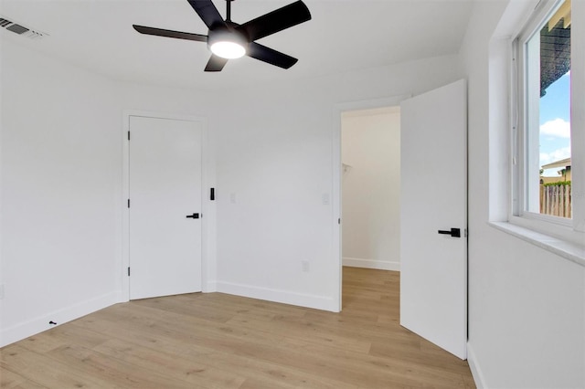 unfurnished bedroom featuring ceiling fan, light wood-style flooring, visible vents, and baseboards