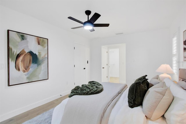 bedroom featuring a ceiling fan, light wood-style flooring, and baseboards