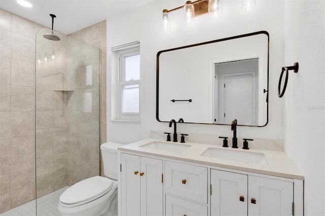 full bathroom with a tile shower, a sink, and toilet