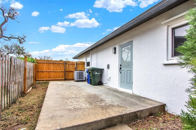 view of property exterior featuring a patio, central AC unit, a fenced backyard, and stucco siding