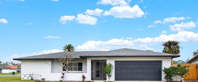 ranch-style house with concrete driveway, fence, and an attached garage